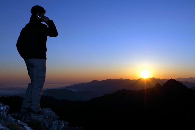 Notfall am Berg: Person im Gebirge am Handy