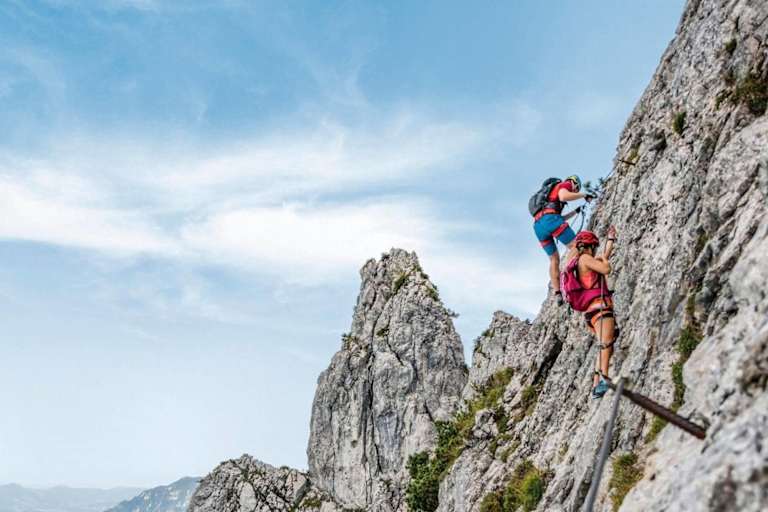 Kletterer am Pidinger Klettersteig und im Hintergrund das Alpenvorland