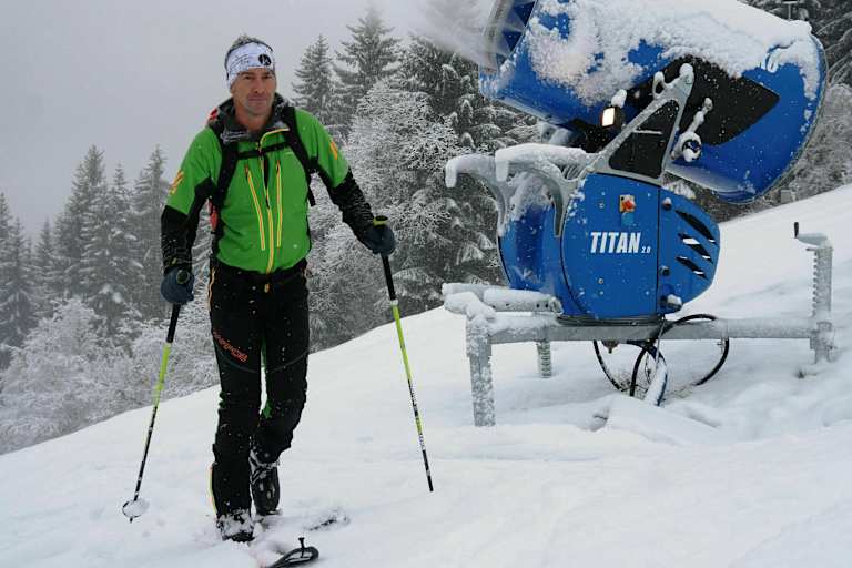 Skitourengeher im Skigebiet auf präparierter Piste