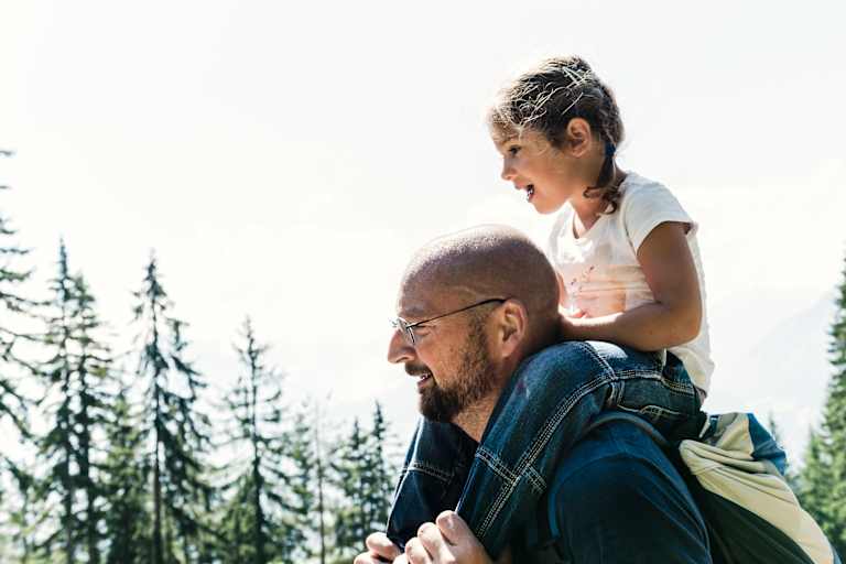Das kleine Mädchen Lina sitzt auf den Schultern ihres Papas.