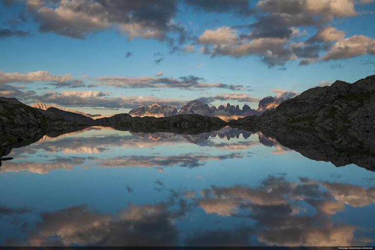 Ein schwarzes Dolomitenpanorama spiegelt sich im Schwarzen See.