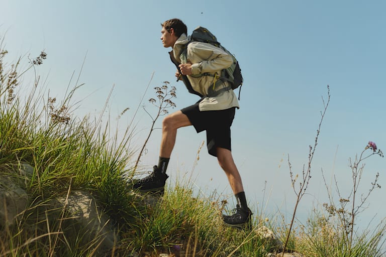 Ein Mann mit Wanderschuhen von Salomon auf dem Weg zum Ziel.