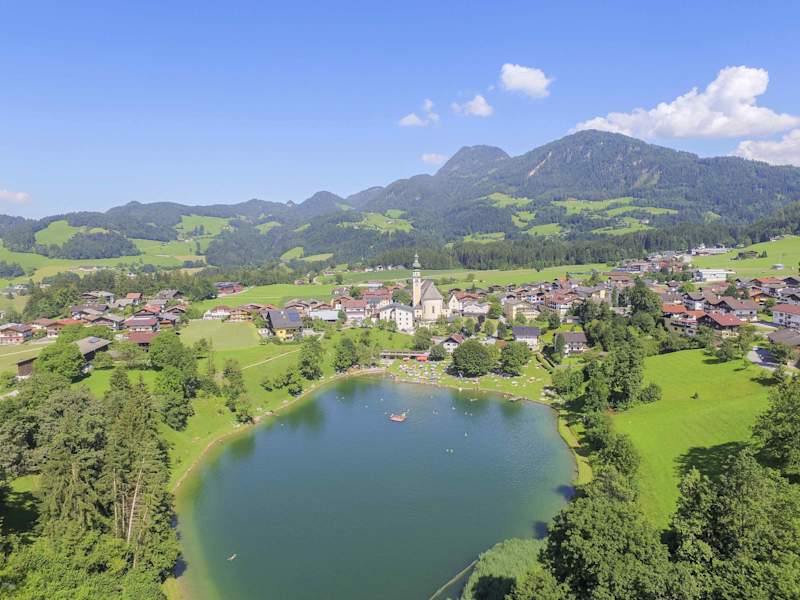 Reith im Alpbachtal mit seiner markanten Kirche und dem Badesee