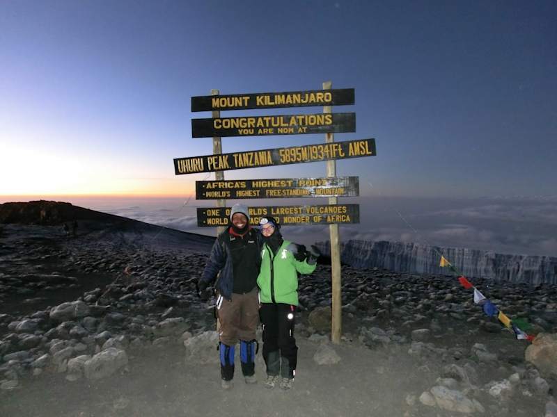 Bei Sonnenaufgang erreichen wir den 5.895 m hohen Uhuru Peak, den Gipfel des Kilimanjaro.