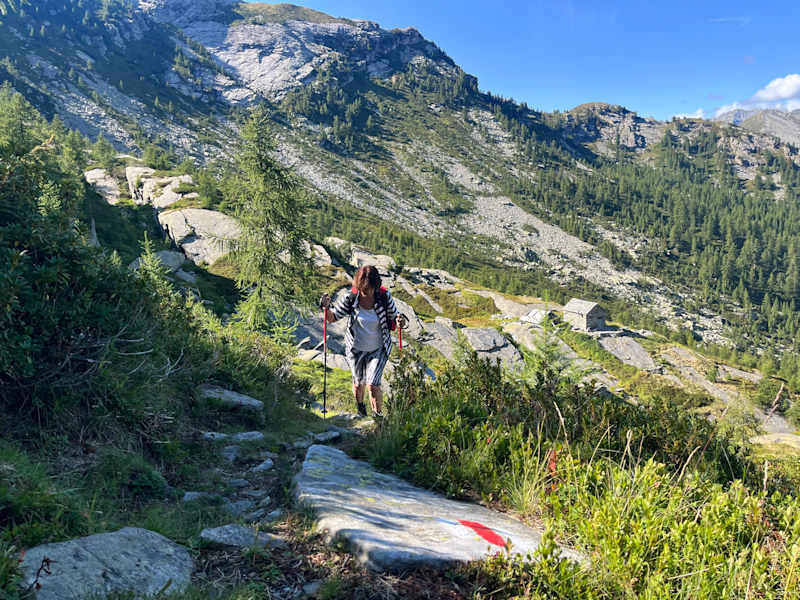 Die weiß-rote Markierung zeigt das offizielle Wanderwegenetz an. Im Hintergrund Corte del Pèzz.