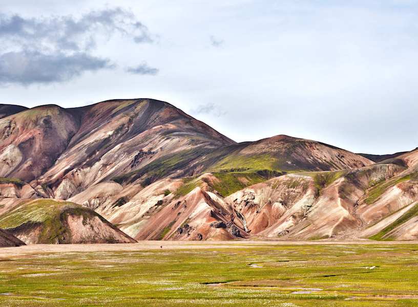 Landmannalaugar: Einsamer Wanderer in der Vulkanlandschaft von Landmannalaugar im Hochland. Buntes Rhyolith-Gestein teils mit Moos überwachsen.