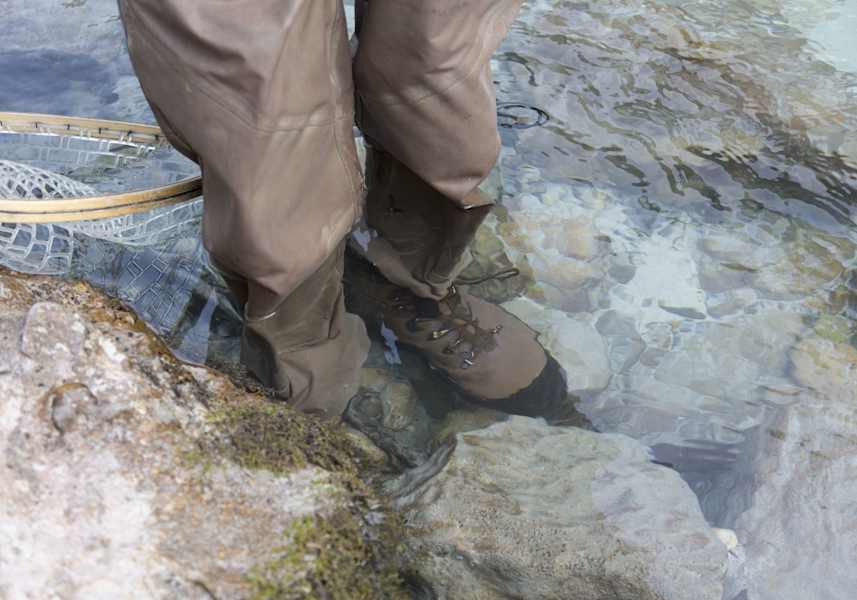 Die Füße des Fischers im Bachbett.