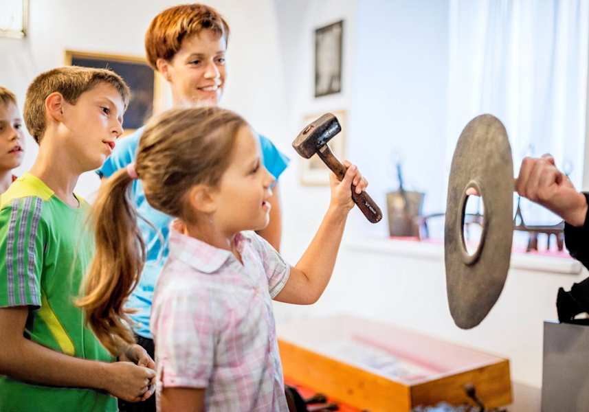 Schmiedewerkzeuge im Hammerherrenmuseum werden von Kindern ausprobiert