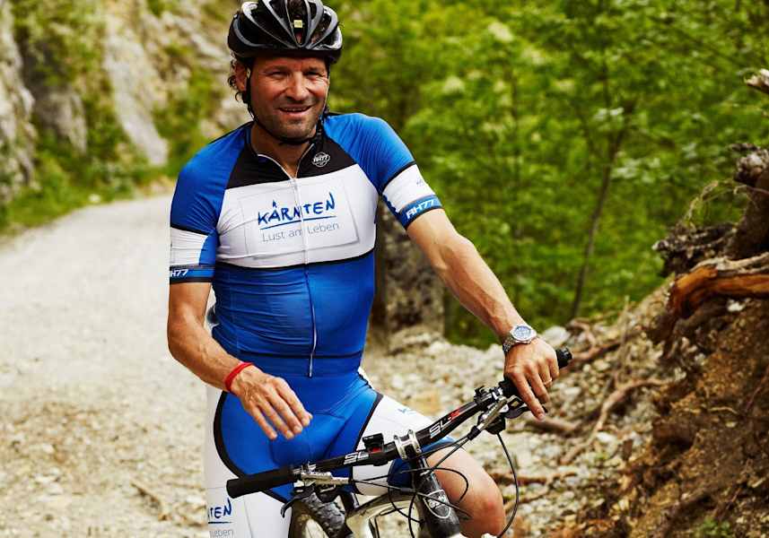 Radfahrer im Fahrraddress auf einem Mountainbike am Berg