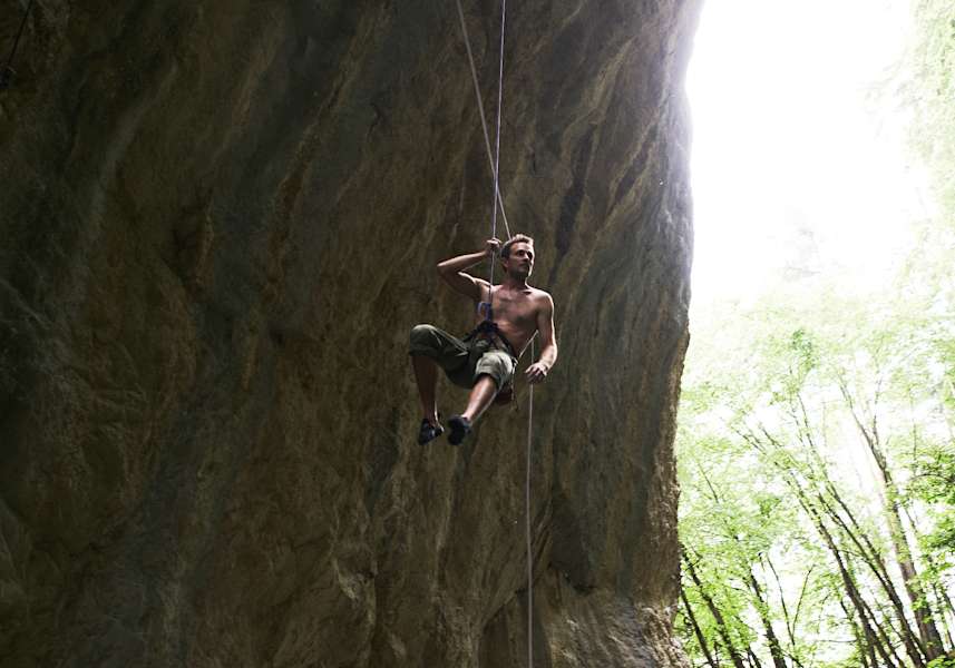 Kletterer hängt an der Wand in den Seilen