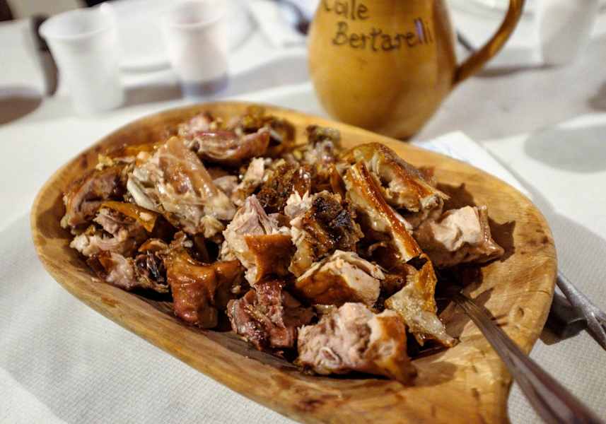 Gegrillte Ziege serviert auf einem typischen Holzteller