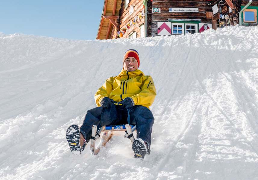 Ein Gast der Südwiener Hütte beim Rodeln ins Tal