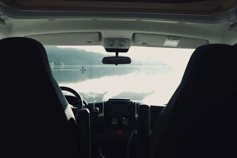 Blick vom Campingplatz direkt am Wasser auf das klare Wasser des Sees. Feste Stellplätze gibt es hier nicht, man spricht sich mit den Nachbarn ab.