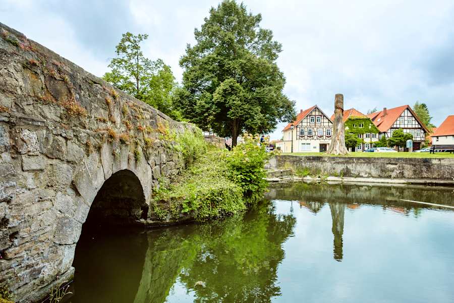 Coppenbrügge bei Hameln: Über den Burggraben der Wasserburg spannt sich eine Brücke zum Fachwerkstädtchen