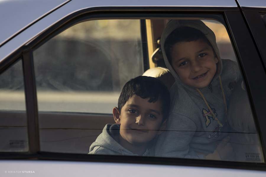 Zwei Kinder blicken neugierig aus dem Autofenster