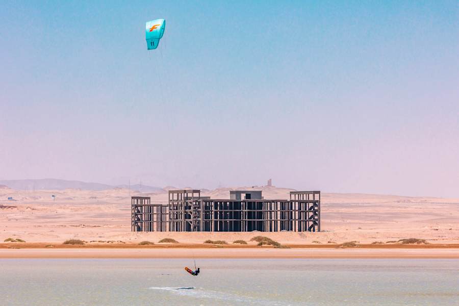 Kitesurfer in Ägypten vor einem unfertigen Gebäude.