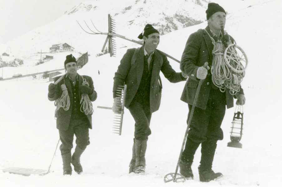 Winter im Gebirge: Drei Männer unterwegs zum Wettbewerb Burtenbinden