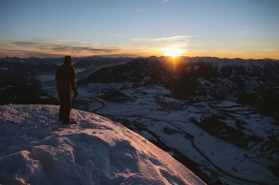 Stefan Pointner genießt die ersten Sonnenstrahlen am Gipfel des Grimming. Das Ennstal weiter unten liegt noch im Dornröschenschlaf.