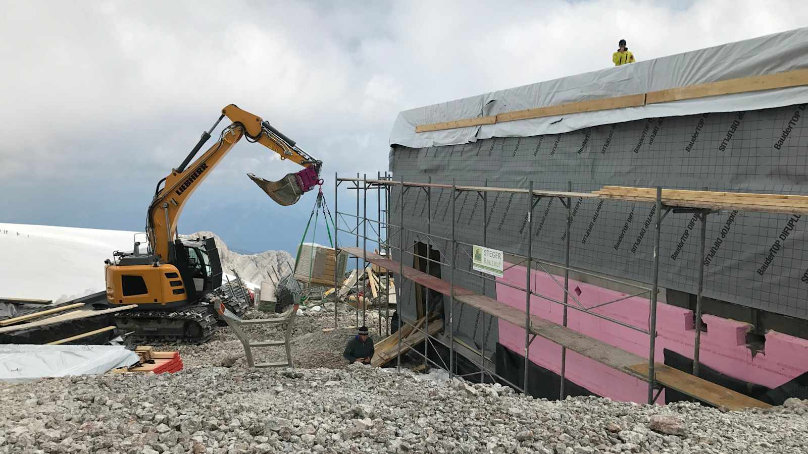 Immer wieder muss der unfertige Holzbau aufgrund schlechten Wetters eingepackt werden.