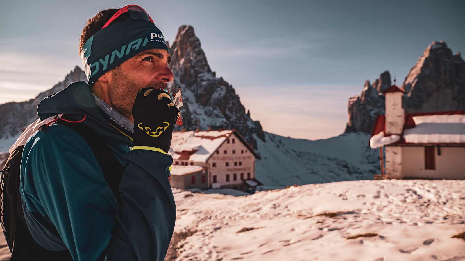 Jakob Herrmann gönnt sich einen Snack während dem AlpFrontTrail in den Südtiroler Dolomiten, die Drei Zinnen im Hintergrund