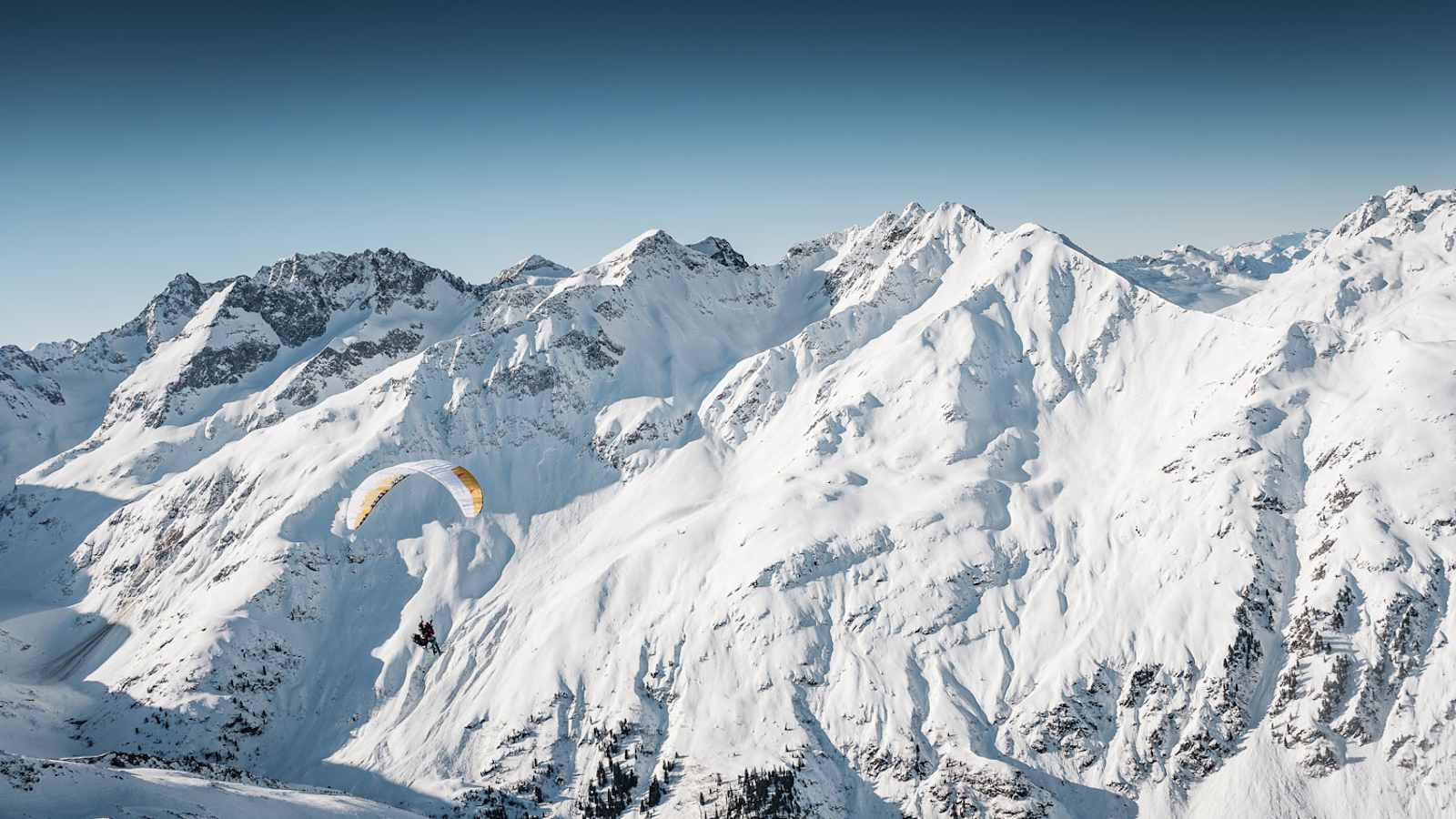 Lautlos und elegant geht es mit dem Paragleiter über das Moostal, zu unberührten Hängen und grandiosen Abfahrten.