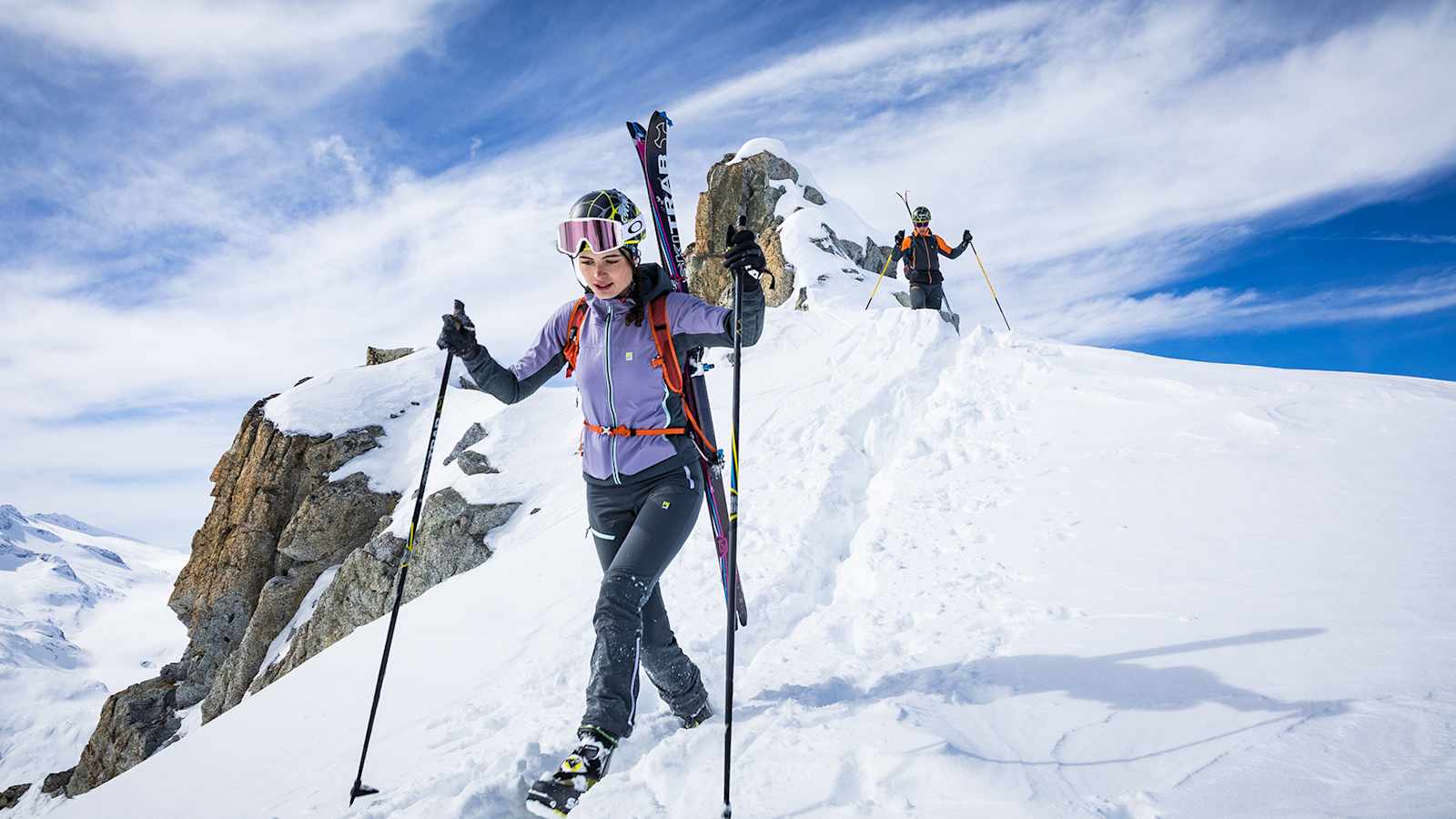 zwei skifahrer auf dem berggipfel am weg nach unten