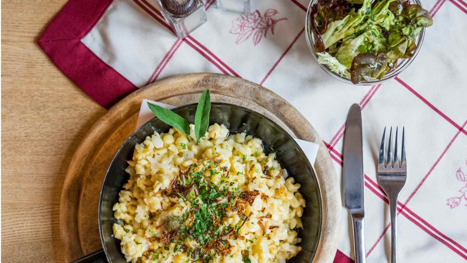 Kasnocken serviert mit einem Salat.