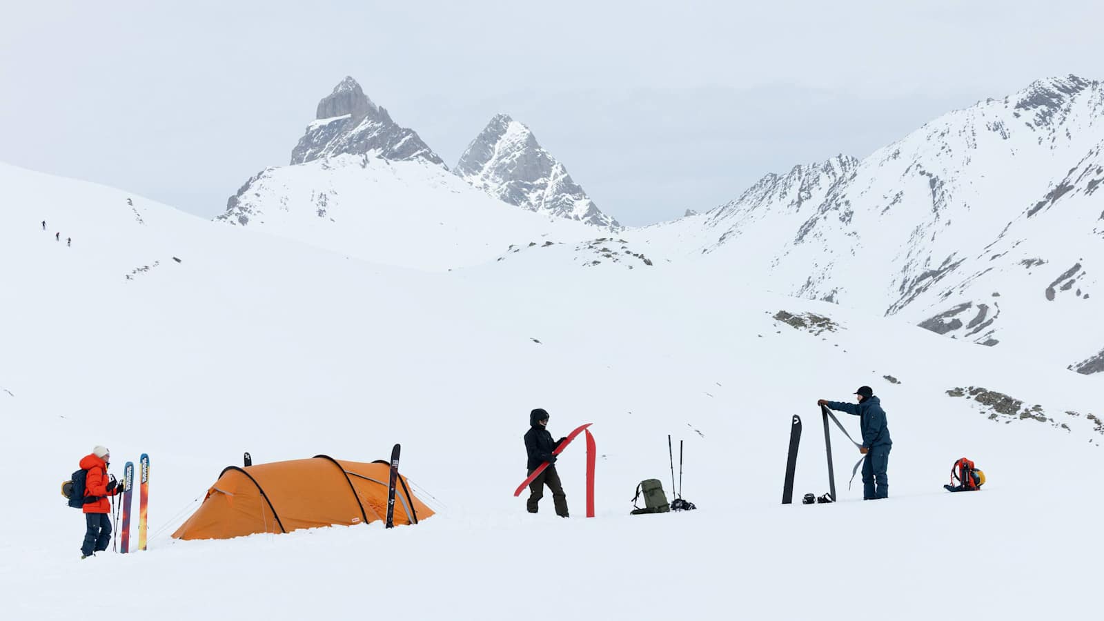 Drei Personen sind mit der neuen Bertagen-Kollektion von Fjällräven ausgerüstest und bereiten ihre Skitouren-Ausrüstung auf.