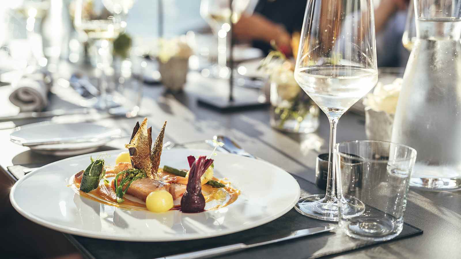 Ein Teller, auf dem Faingarniert, ein Fisch und andere regionale Zutaten zu finden sind.
