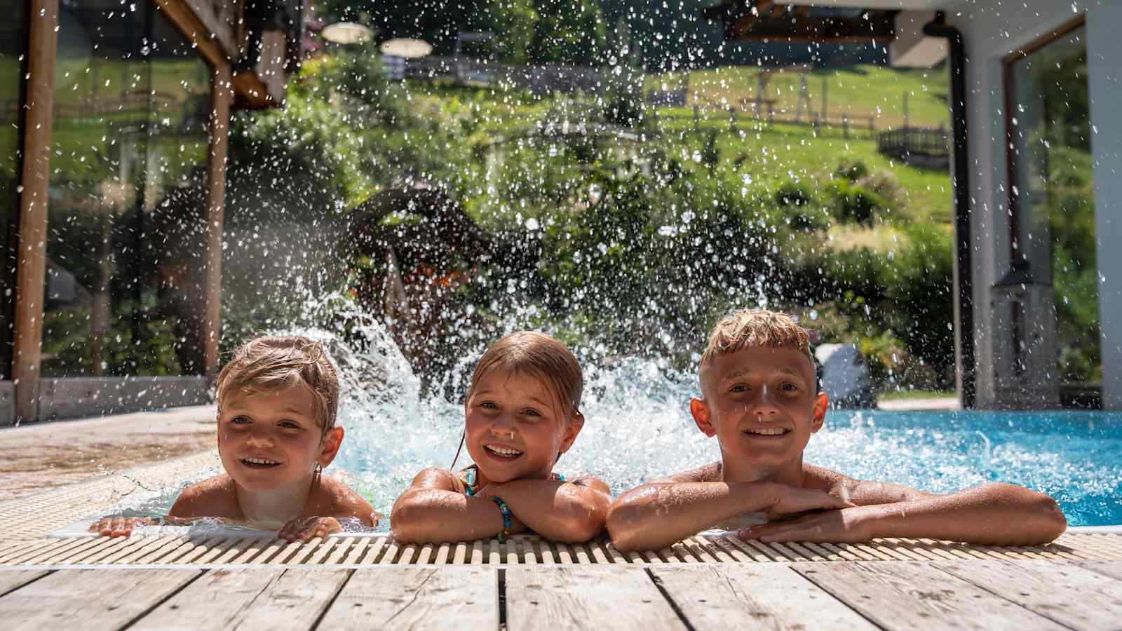Kinder platschen im Schwimmbecken