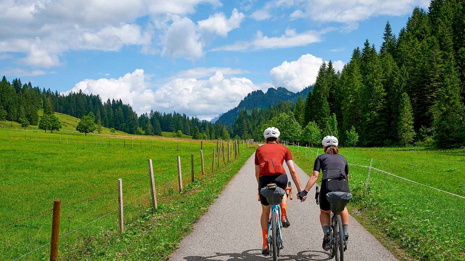 Zwei Radfahrer halten sich die Hände während der Tour.