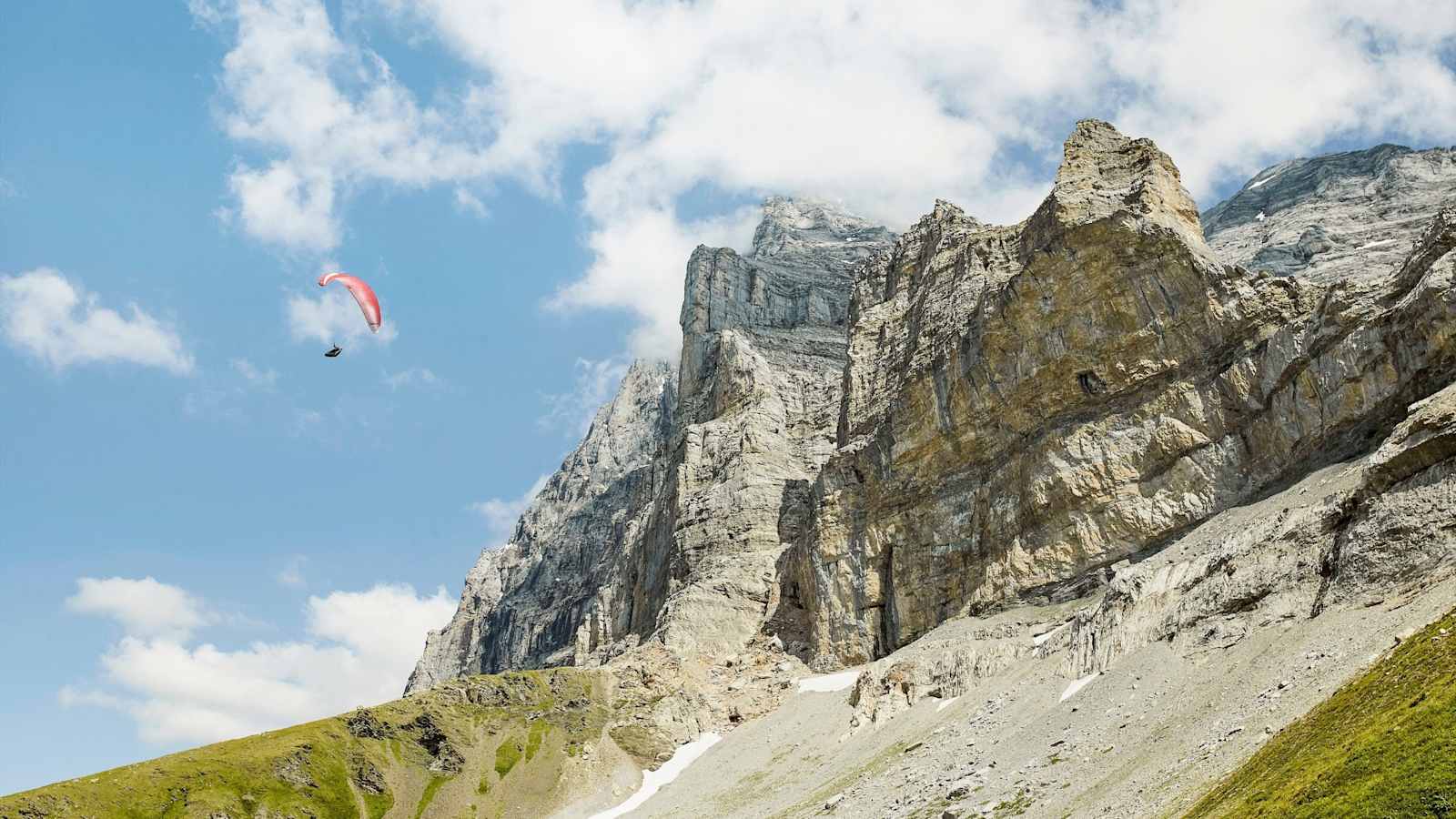 Ein Sportler mit einem Paragleiter in der Luft.