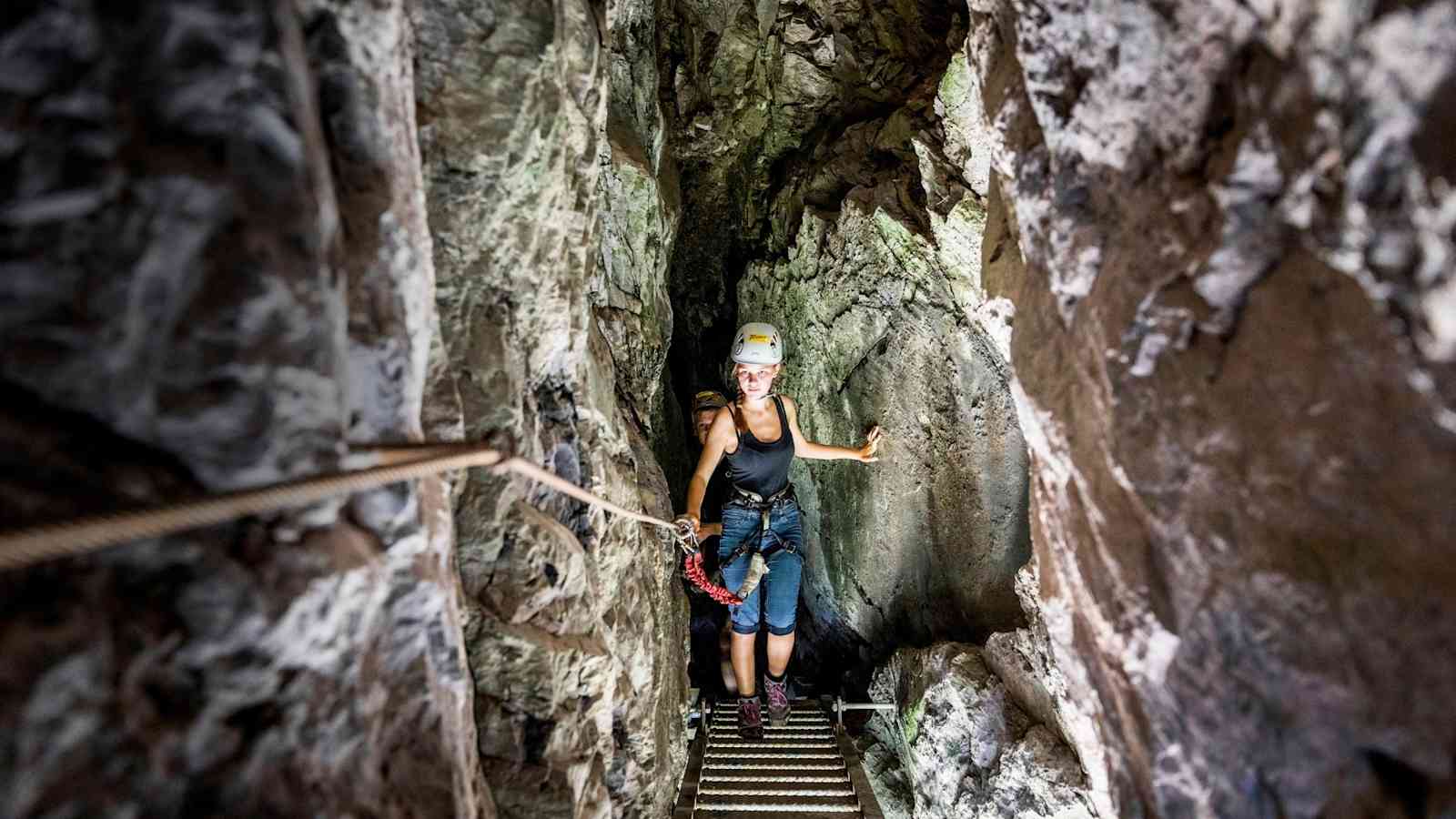 Bergsteiger durchqueren einen Tunnel.