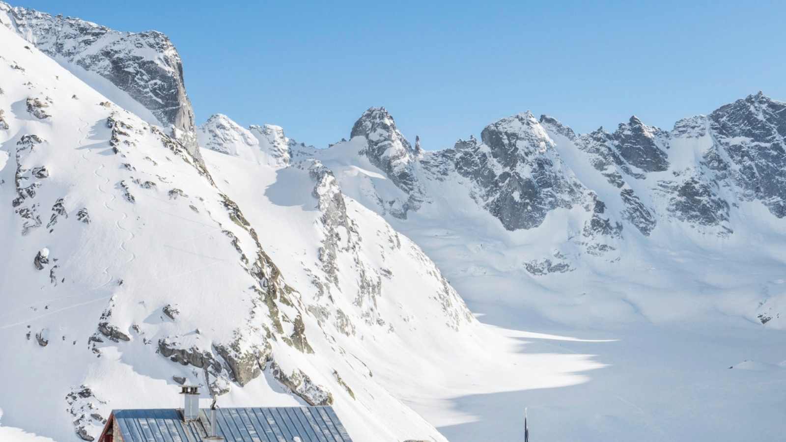 Die Hütte umgeben von einer Schneelandschaft.