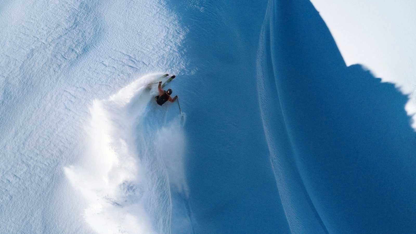 Ein Freerider zieht Schwünge in den Schnee.