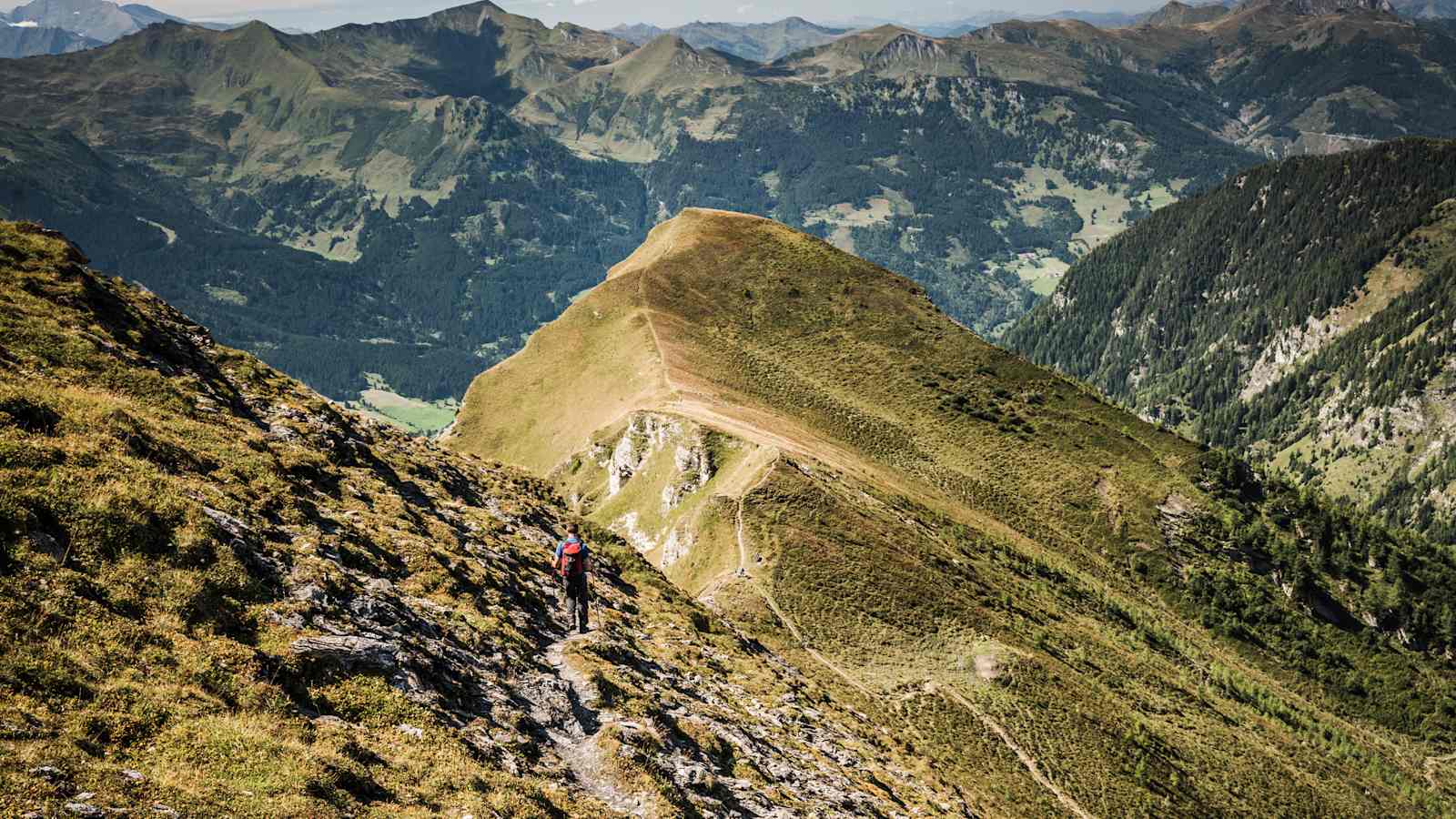 Ein Wanderer vor wunderschönem Bergpanorama.