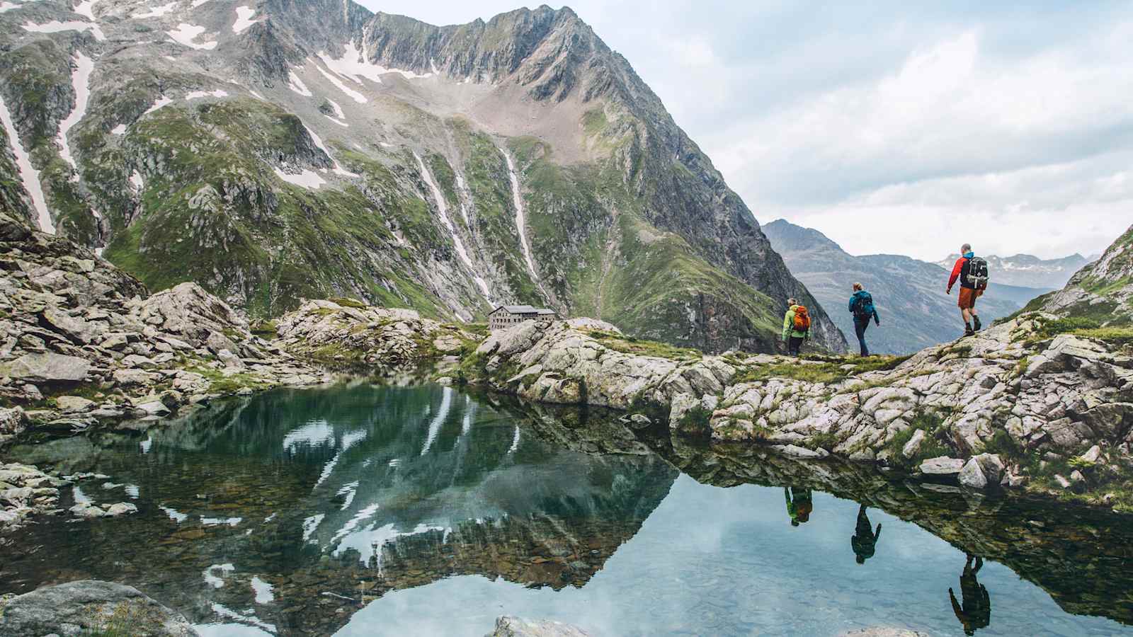 Drei Wanderer vor wunderschönem Bergpanorama.