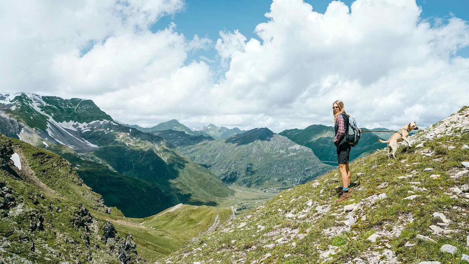 Eine Wanderin genießt den Ausblick auf die Berglandschaft.