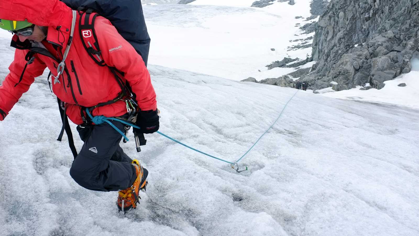 Eingehängte Fixpunkte: Wenn es steiler wird, können eingehängte Fixpunkte (hier eine Eisschraube) einen kompletten Seilschaftsabsturz verhindern. Dafür gibt es unterschiedliche Techniken, die situationsbedingt korrekt angewendet werden müssen.