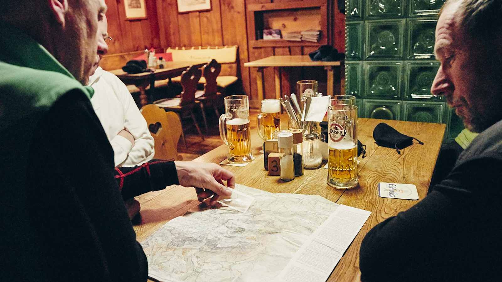 Die Crew sitzt vor einen Karte in der gemütlichen Stube der Ostpreußenhütte.