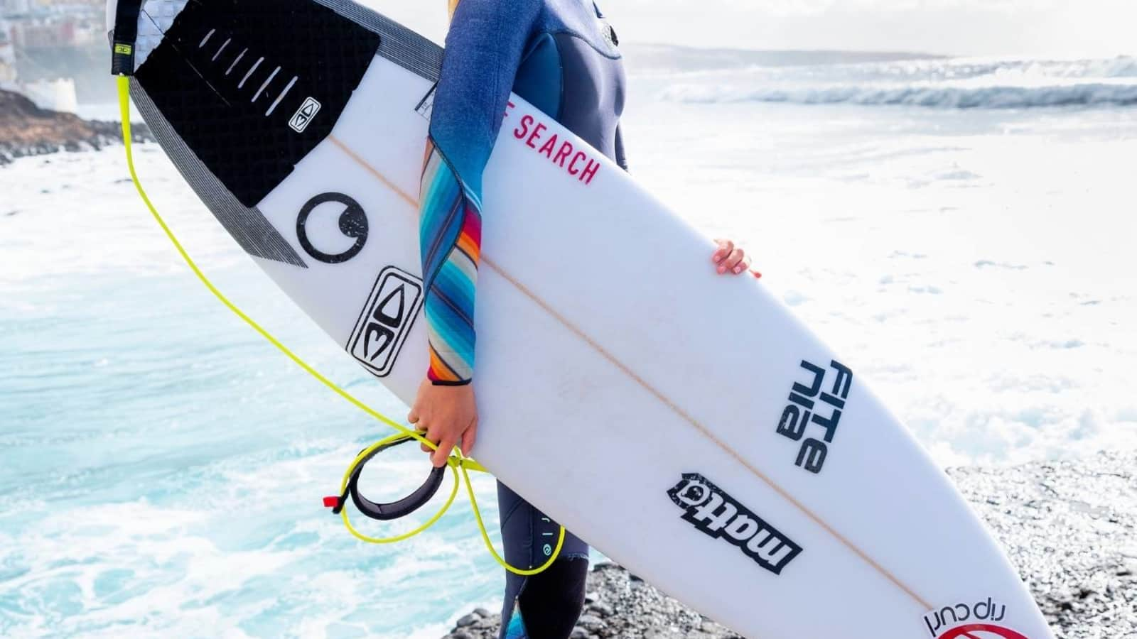 Eine Surferin mit ihren Board am Strand