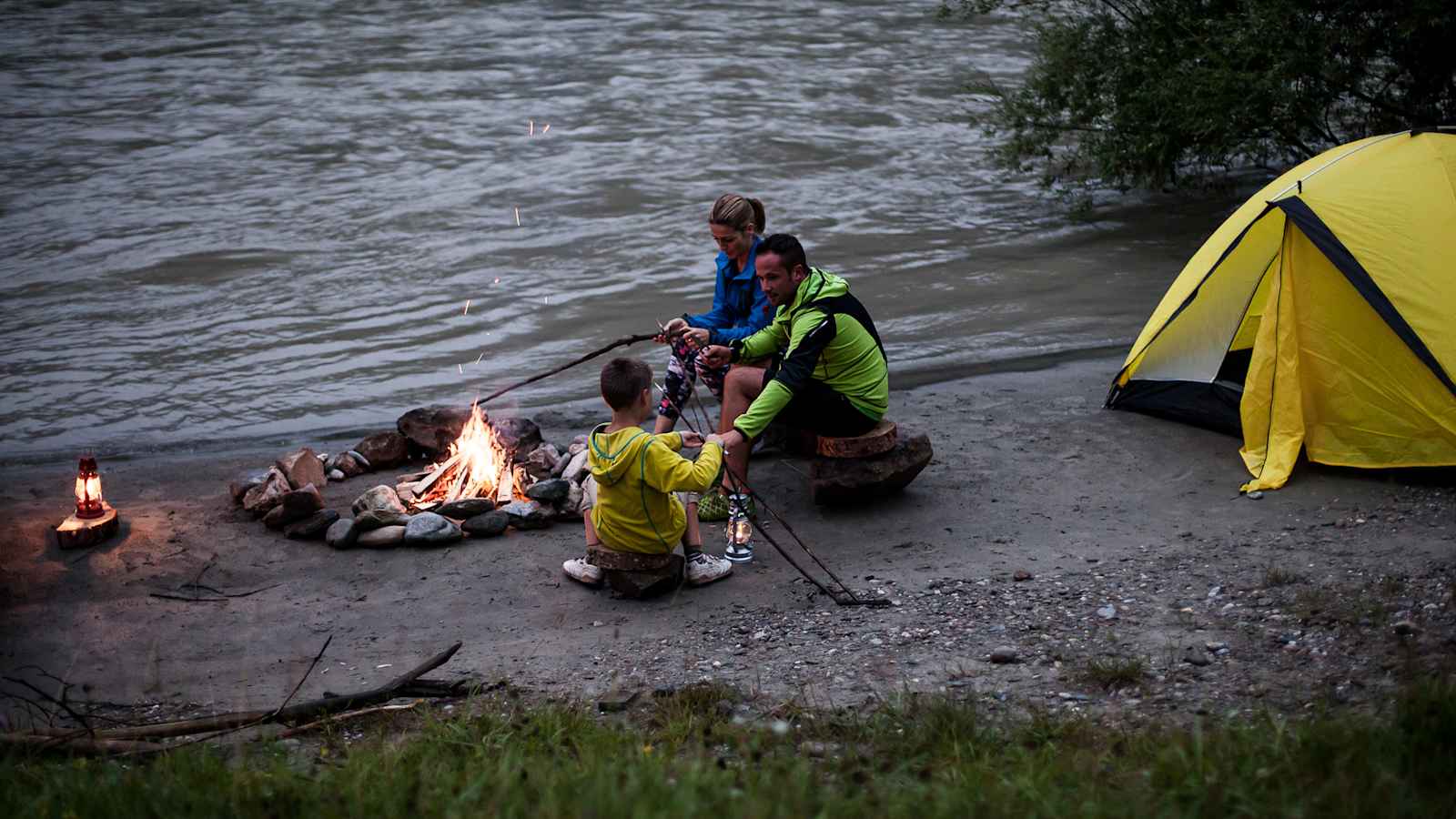 In der Dämmerung wird ein Lagerfeuer entfacht.