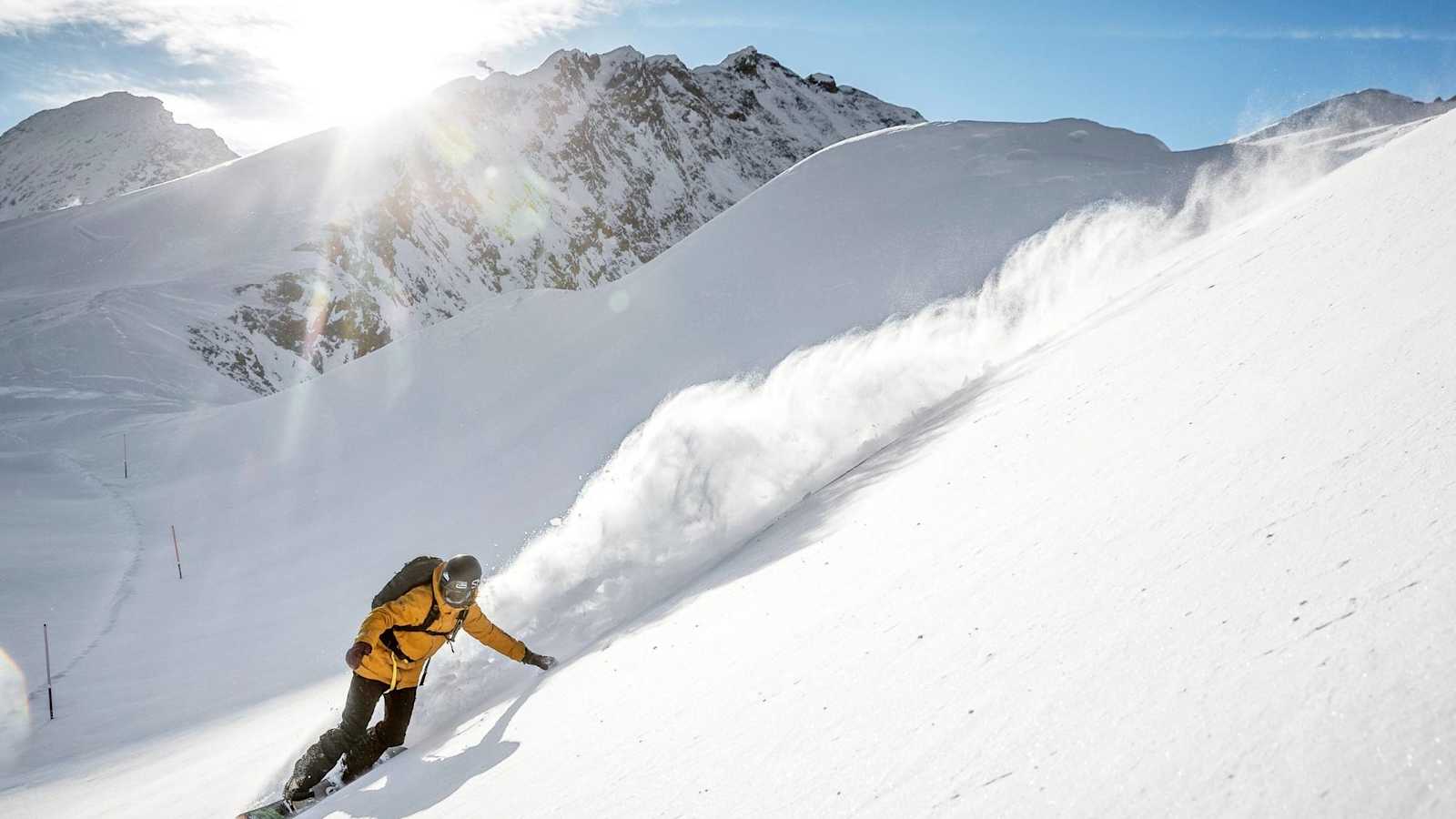 Die Snowboarderin fährt den unverspurten Hang