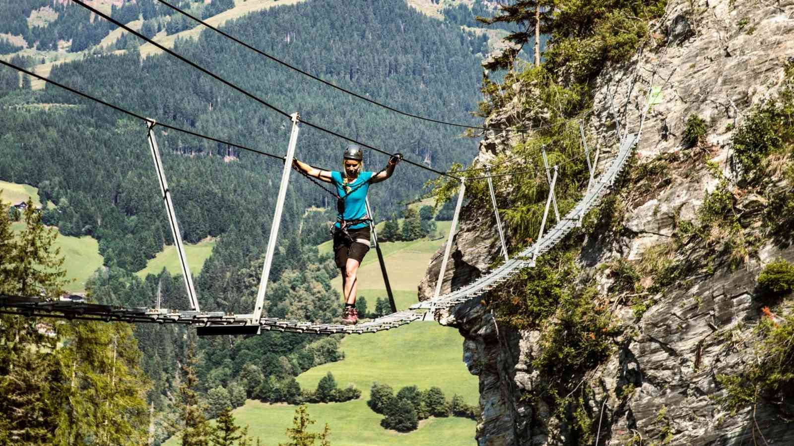 Ein Kletterer überquert die Seilbrücke.