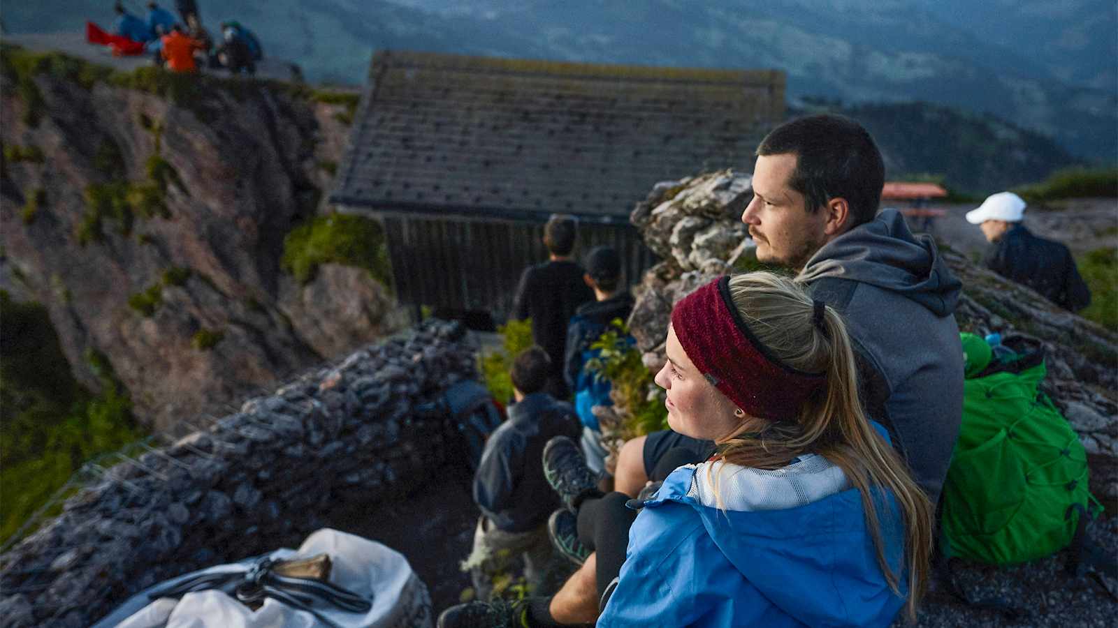 Menschen sitzen wartend auf den Felsen.