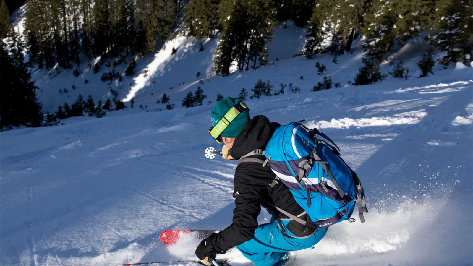 Ein Skifahrer zieht Schwünge auf einer steilen Piste.