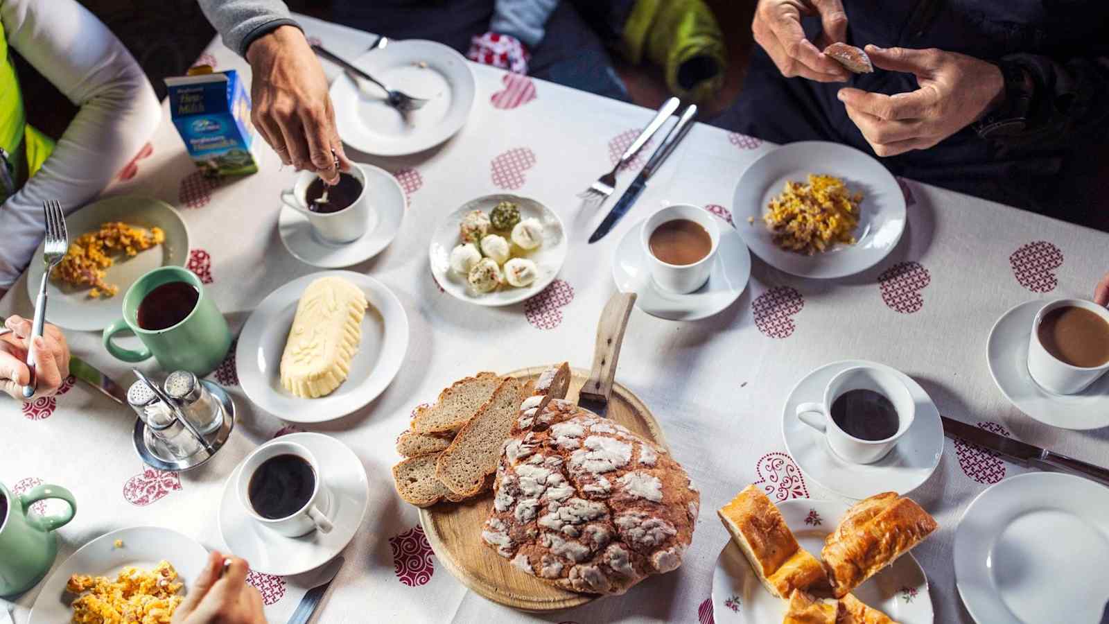 Ein gedeckter Frühstückstisch voller Köstlichkeiten wie Bauernbrot, Butter und Kaffee.