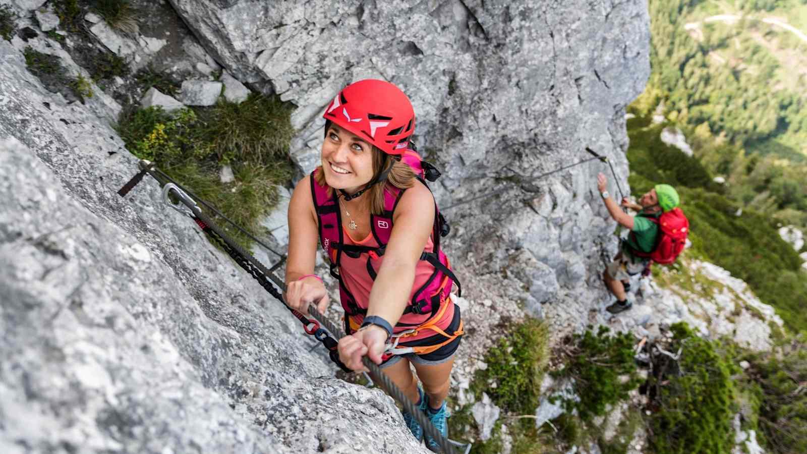 Kletterin überwindet eine C-Passage in der Felswand