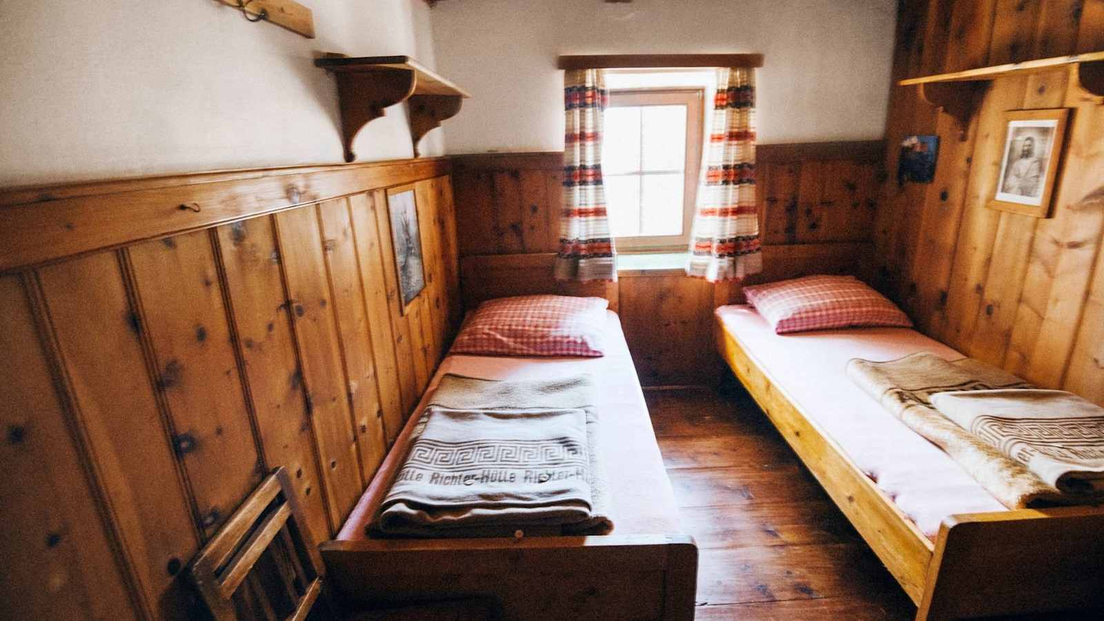 Die urigen Zimmer aus Zirbenholzmöbel mit klassisch rotkarierter Bettwäsche