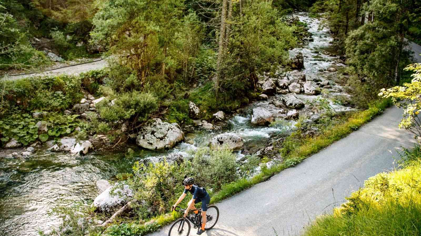 Ein Radfahrer fährt entlang eines Flusses.